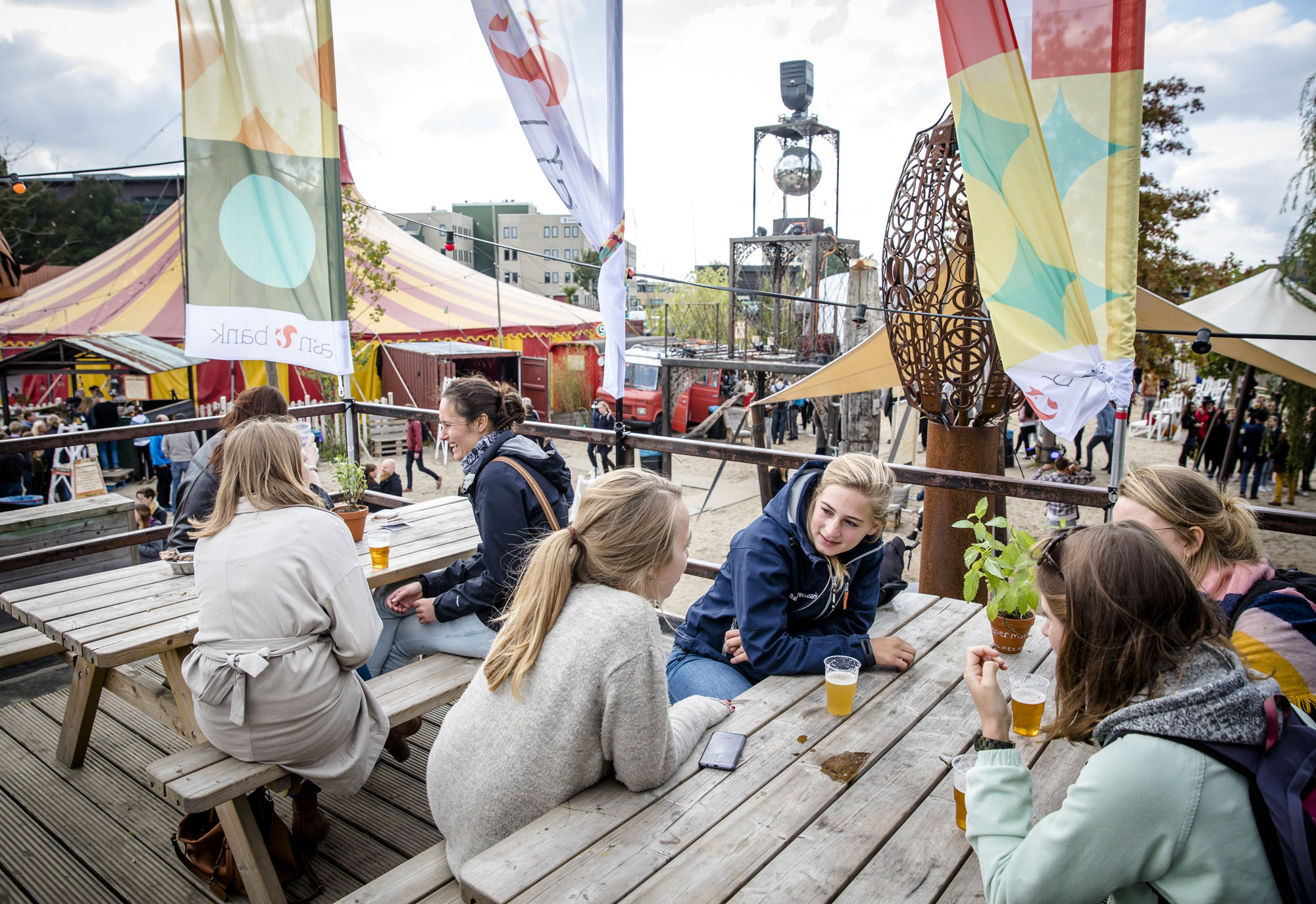 mensen zitten gezellig aan een tuintafel