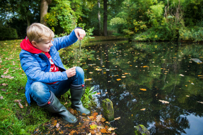 Jongetje neemt een watermonster in een sloot