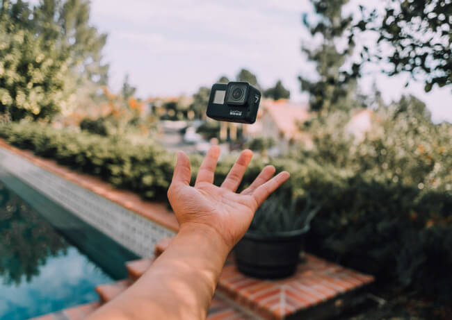 Hand die een Go Pro omhoog gooit