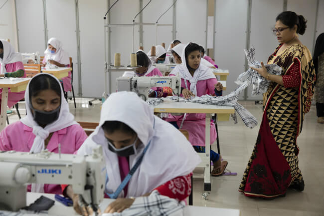 vrouwen achter de naaimachine in een fabriek