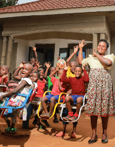 vrouw met kinderen in een speeltuin in Uganda